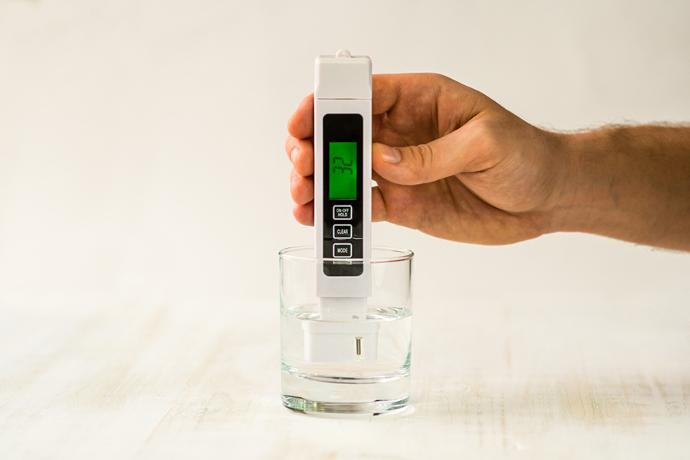 TDS meter showing the ppm level of a glass water