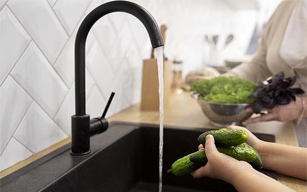 lady washing fresh vegetables in pure water