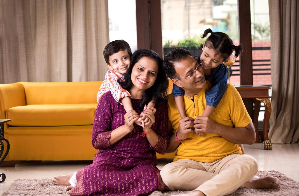 father, mother and two kids hug and play as they are happy that they drink pure water